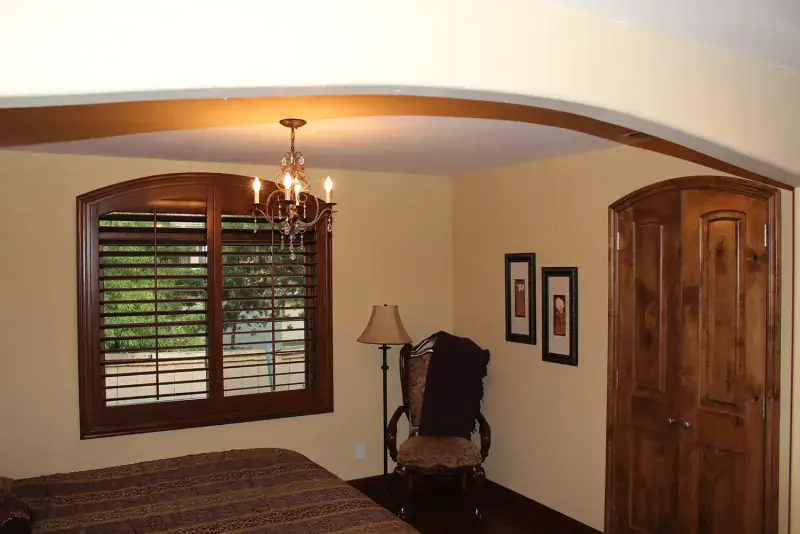 Custom basswood plantation shutters with arched top in San Diego home